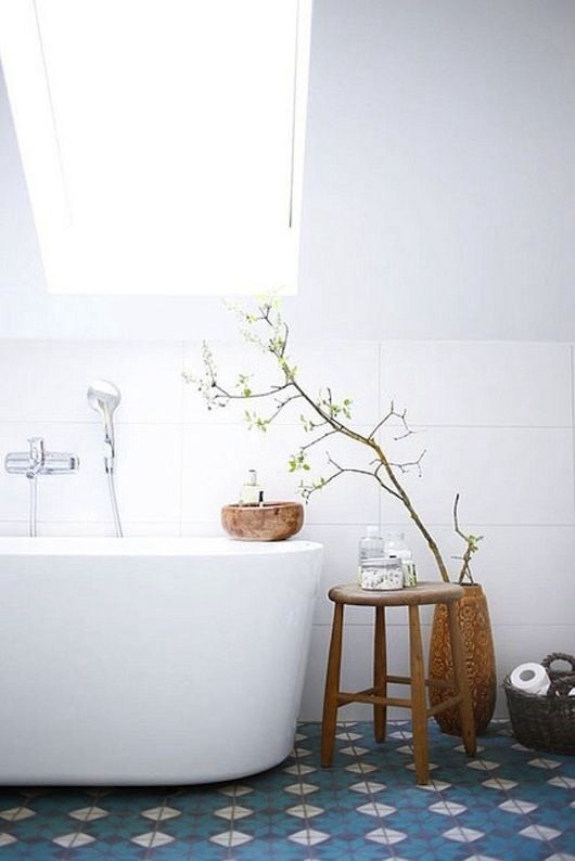 Un sol aux motifs anciens avec une baignoire moderne