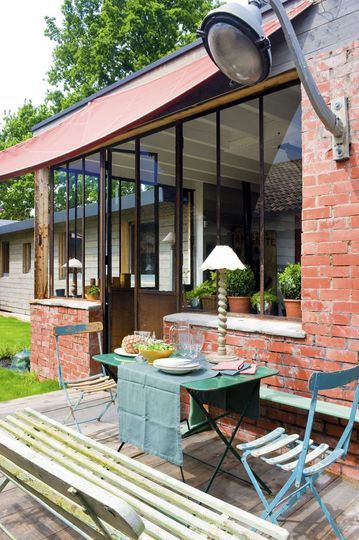 Terrasse en bois et façade en brique et verriere